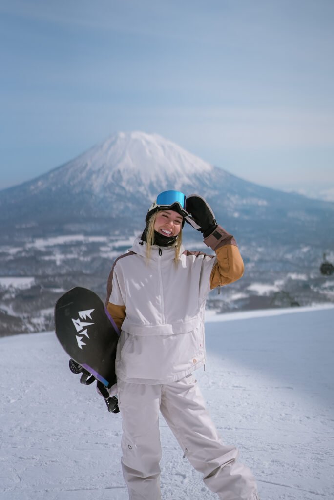 Snowboarder posing in front of Mt. Yotei