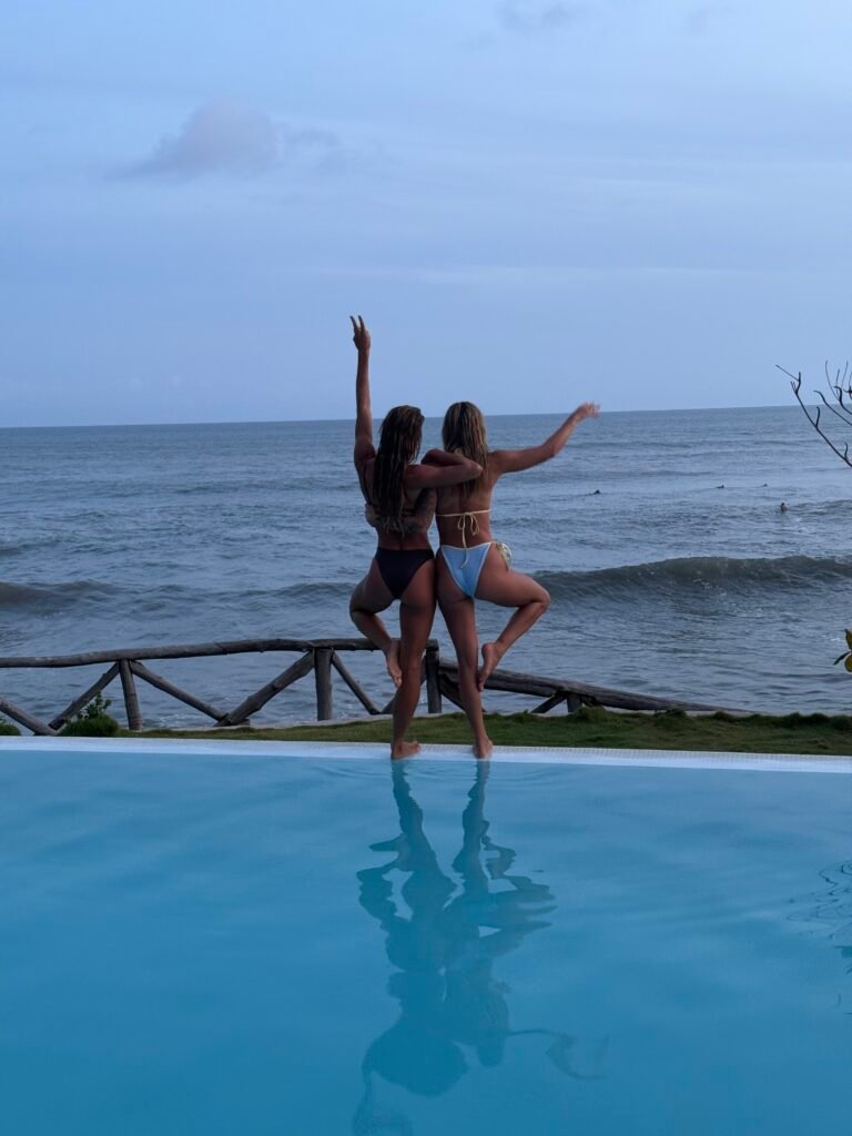 Friends on the edge of an infinity pool overlooking the ocean