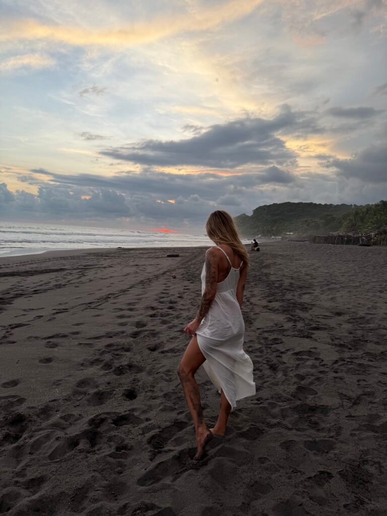 Me in a flowy white dress on the beach at sunset in El Salvador