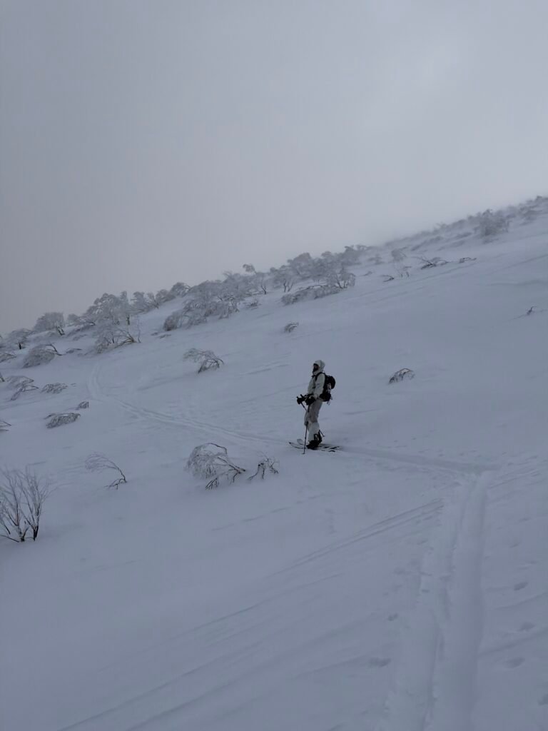 Lone rider hiking up an open snowfield