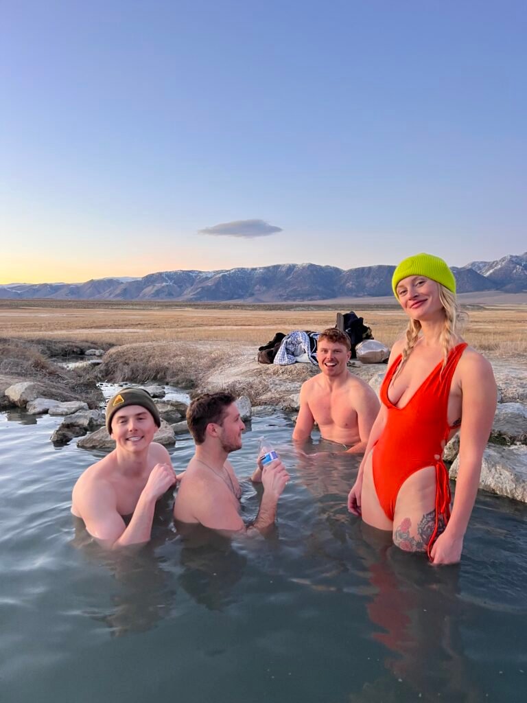 Friends soaking in a hot spring near Mammoth Lakes with the Sierra behind