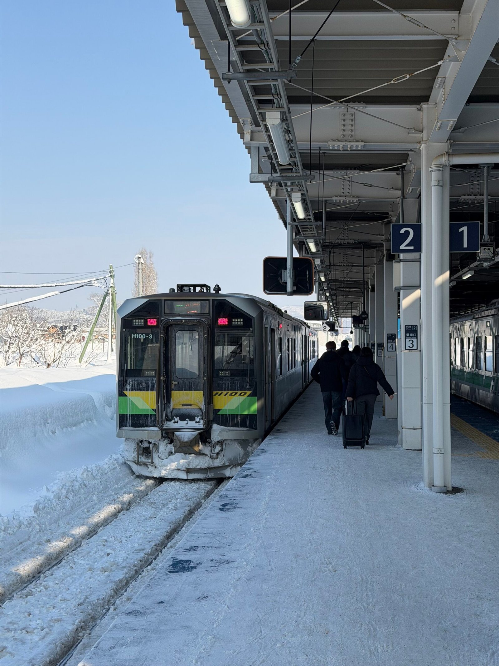 Train arriving at a snowy station platform in Hokkaido