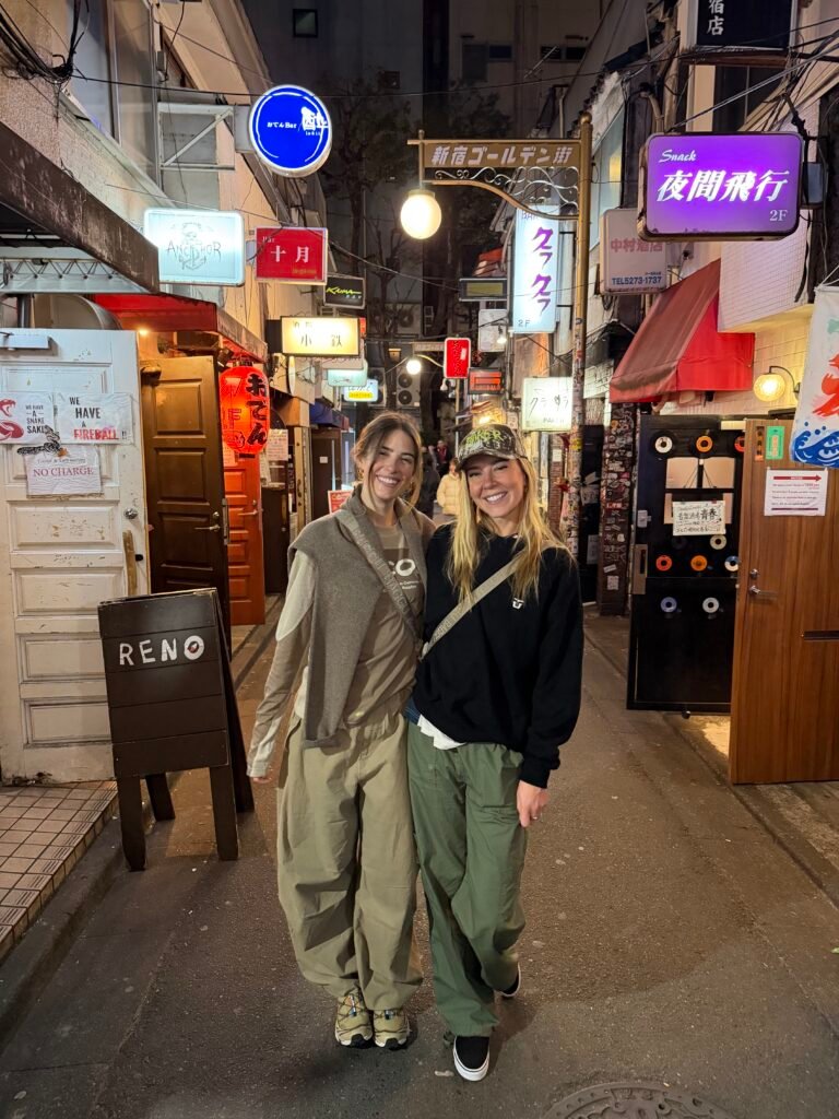 Two friends in a narrow Tokyo alley at night