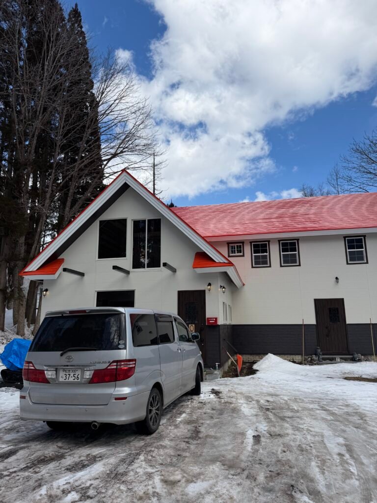 The Owl Nest lodge in Otari near Hakuba with a van parked out front