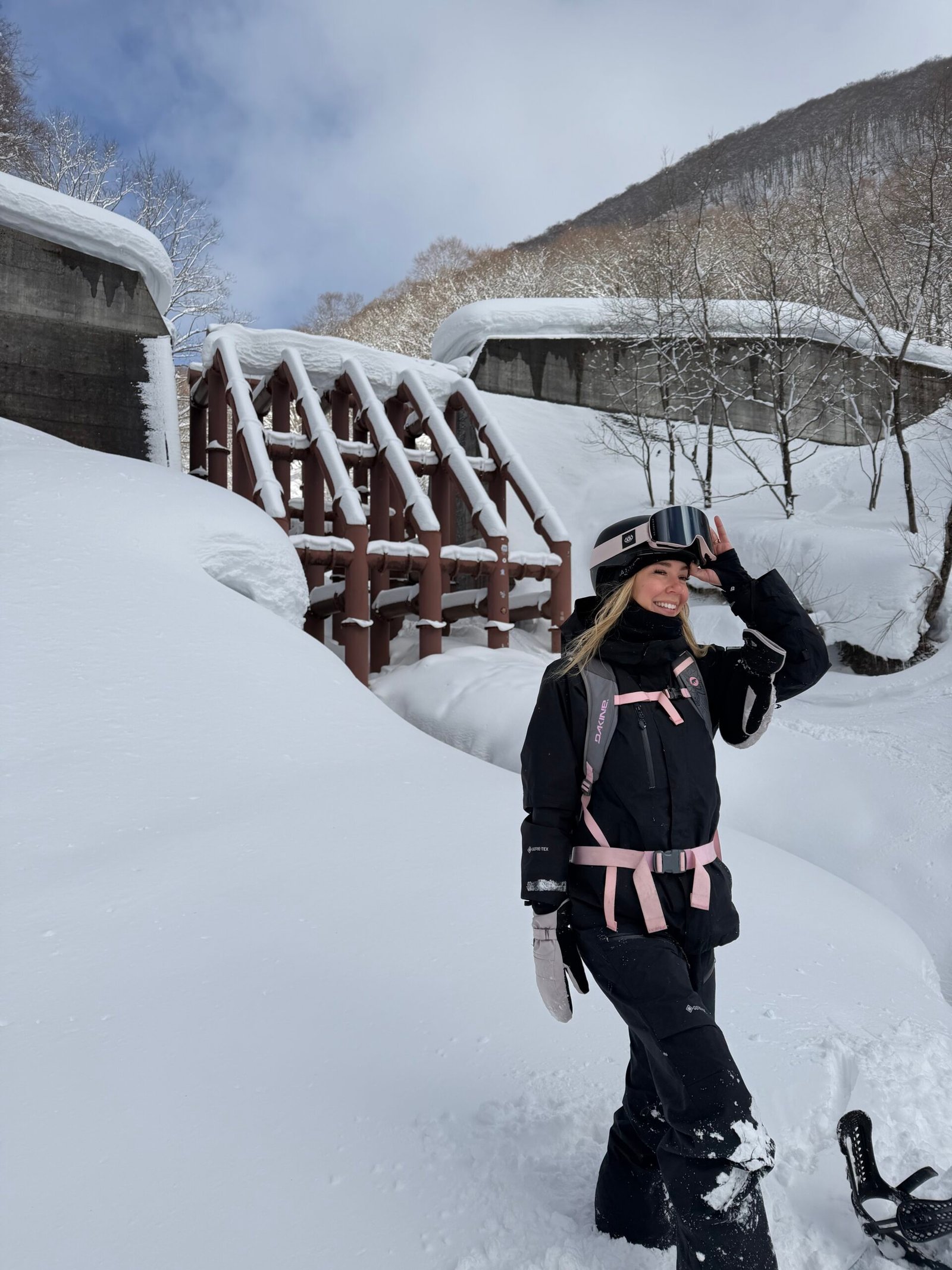 Snowboarder in front of the dam on the dam run at Hakuba Cortina