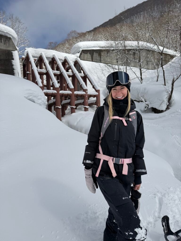 Snowboarder in deep snow below the dam at Hakuba Cortina