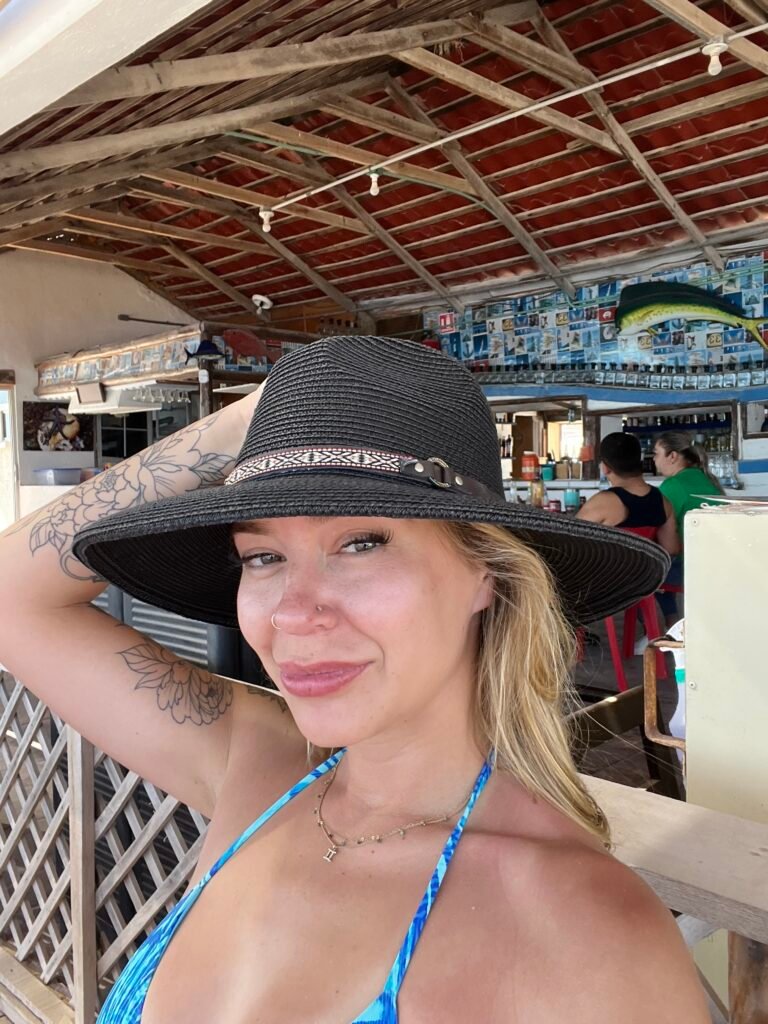 Me in a sun hat at a beach restaurant at Playa El Tecolote, La Paz