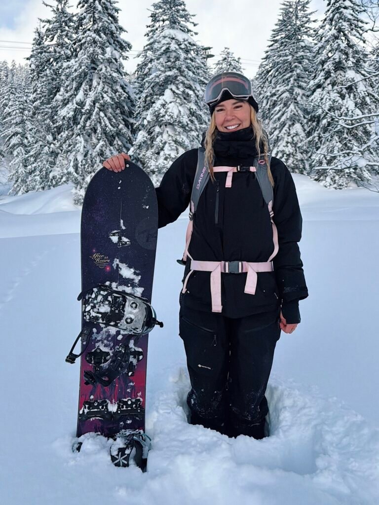 Holding my snowboard in deep snow among the trees in Japan